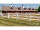 Equestrian barn featuring white fencing, multiple stalls, and lush green pastures, creating a serene and picturesque setting at 1020 Equipoise Dr, Indian Trail, NC 28079