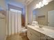 Well-lit bathroom features a shower-tub combo, white vanity and neutral-toned tiles at 1020 Equipoise Dr, Indian Trail, NC 28079