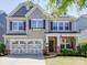 Charming two-story home with a front porch, stone accents, and a two-car garage at 1020 Equipoise Dr, Indian Trail, NC 28079