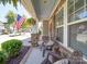 Inviting front porch with stone accents, rocking chairs, and an American flag at 1020 Equipoise Dr, Indian Trail, NC 28079