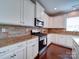 Modern kitchen featuring granite countertops, brick backsplash, and white cabinetry at 1020 Equipoise Dr, Indian Trail, NC 28079