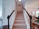 Carpeted staircase with white railings and dark wood accents at 1020 Equipoise Dr, Indian Trail, NC 28079