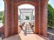 Charming brick walkway framed by a brick archway and a white pergola-covered path, invites you to explore the community at 1020 Equipoise Dr, Indian Trail, NC 28079