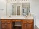 Bathroom featuring double sinks, wood cabinetry, a large mirror, and a view into the shower and toilet area at 10316 Willingham Rd, Huntersville, NC 28078
