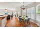 Open-concept dining area with hardwood floors and decorative hanging light fixture, connected to living room at 10316 Willingham Rd, Huntersville, NC 28078
