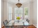 Dining area featuring a modern glass table beneath a decorative light fixture and large windows at 10316 Willingham Rd, Huntersville, NC 28078