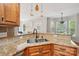 Granite countertops in this kitchen with a double sink, cabinet space, and breakfast bar overlooking living area at 10316 Willingham Rd, Huntersville, NC 28078