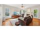 Inviting living room featuring hardwood floors, a cozy fireplace, and ample natural light from large windows at 10316 Willingham Rd, Huntersville, NC 28078