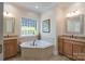 Bathroom with corner tub, tile flooring, and dual vanities at 11008 Round Rock Rd, Charlotte, NC 28277