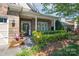 Inviting front porch with a brick entryway, trimmed landscaping, and decorative plants in a charming setting at 11008 Round Rock Rd, Charlotte, NC 28277