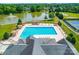 Community pool with plenty of lounge chairs, cabanas, and a lake in the background at 1103 Cooper Ln, Indian Trail, NC 28079