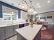 Open kitchen with island, stainless steel appliances, tile backsplash, and view into the open living area at 1103 Cooper Ln, Indian Trail, NC 28079