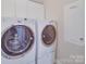 Modern laundry room with front loading washer and dryer, ample storage and utility panel at 1103 Cooper Ln, Indian Trail, NC 28079