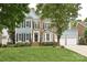 Charming two-story home with blue siding, brick accents, black shutters, a well-manicured lawn, and mature trees at 11232 Tradition View Dr, Charlotte, NC 28269