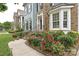 Exterior view of a house featuring a brick facade, blue siding, lush landscaping, and a sidewalk leading to the entrance at 11232 Tradition View Dr, Charlotte, NC 28269