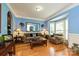 Living room with hardwood floors, blue walls, a bay window, and comfortable seating with lamps and tables at 11232 Tradition View Dr, Charlotte, NC 28269