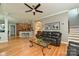 Comfortable living room with a leather sofa, ceiling fan, and access to the kitchen with bar seating at 11232 Tradition View Dr, Charlotte, NC 28269
