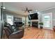 Cozy living room featuring hardwood floors, a fireplace with a TV above, and comfortable leather seating at 11232 Tradition View Dr, Charlotte, NC 28269