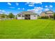 Expansive back yard with lush lawn and a charming home featuring a wooden deck and white picket fence at 1128 Rosecliff Dr, Marvin, NC 28173