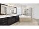 Elegant bathroom with a dark vanity, soaking tub, walk-in shower, and ample natural light at 1128 Rosecliff Dr, Marvin, NC 28173