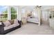 Spacious bedroom featuring a luxurious four-poster bed, neutral tones, and a comfortable seating area at 1128 Rosecliff Dr, Marvin, NC 28173