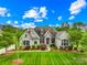 Beautiful brick home featuring manicured landscaping and mature trees on a sunny day at 1128 Rosecliff Dr, Marvin, NC 28173