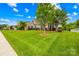 Well-manicured front yard featuring a verdant lawn and mature tree, accentuating the home's inviting curb appeal at 1128 Rosecliff Dr, Marvin, NC 28173