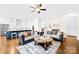 Bright living room featuring hardwood floors, a ceiling fan, and a view into the modern kitchen at 1128 Rosecliff Dr, Marvin, NC 28173