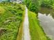 Picturesque walking trail winding beside a serene lake, surrounded by lush greenery, offering a peaceful escape at 1128 Rosecliff Dr, Marvin, NC 28173