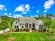 Beautiful brick home featuring manicured lawn, mature trees, and stone accents at 1128 Rosecliff Dr, Waxhaw, NC 28173