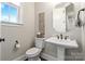 Elegant powder room with a pedestal sink, decorative mirror, and lovely trim at 1149 Grand Oak Dr, Waxhaw, NC 28173