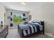Comfortable bedroom boasts natural light from the window with charming blue-striped bedding and decor at 1149 Grand Oak Dr, Waxhaw, NC 28173