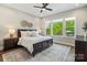 Sun-filled bedroom featuring a large window, ceiling fan, area rug and comfortable furnishings at 1149 Grand Oak Dr, Waxhaw, NC 28173