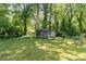 Lush backyard featuring mature trees, a lawn, and two sheds at 1214 Short St, Salisbury, NC 28144