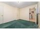 Bedroom featuring white paneled walls and green carpet with a door to a utility room at 1214 Short St, Salisbury, NC 28144