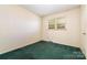 A cozy bedroom featuring green carpeting, a window, and a neutral color scheme at 1214 Short St, Salisbury, NC 28144