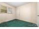 Modest bedroom featuring green carpet, neutral paneled walls, and a window with a view at 1214 Short St, Salisbury, NC 28144