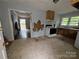 An outdated kitchen featuring cabinets, sink, and electric stove overlooks into the front room at 1224 Bailey St, Albemarle, NC 28001