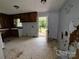 An outdated kitchen provides outside access to a backyard porch via a white door with glass window at 1224 Bailey St, Albemarle, NC 28001