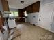 The kitchen features an electric stove, cabinetry, a window, and an exit door with peeling paint at 1224 Bailey St, Albemarle, NC 28001
