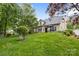 Expansive backyard showcasing a lush lawn, mature trees, and a cozy patio, perfect for outdoor living at 1244 Saint Johns Ave, Matthews, NC 28104