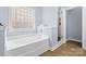 Bright bathroom featuring a soaking tub, a glass-enclosed shower, and a stylish tile design, creating a luxurious space at 1244 Saint Johns Ave, Matthews, NC 28104