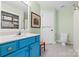 Bright bathroom with vibrant blue vanity, patterned floor tiles, and a well-lit mirror at 1244 Saint Johns Ave, Matthews, NC 28104