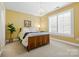 Bedroom featuring a comfortable bed, soft lighting, and a large window with plantation shutters at 1244 Saint Johns Ave, Matthews, NC 28104