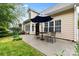 A charming outdoor patio featuring a bistro set and open windows to the home's interior at 1244 Saint Johns Ave, Matthews, NC 28104