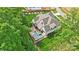 Aerial shot of an estate showcasing a pristine pool, manicured lawn and home nestled amongst mature trees at 13106 Bien Ct, Huntersville, NC 28078