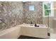Stunning bathroom features a soaking tub with decorative tile and a black tiled floor at 13106 Bien Ct, Huntersville, NC 28078