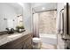 This bathroom has a granite countertop, modern vanity, and shower and bath with curtain at 13106 Bien Ct, Huntersville, NC 28078