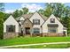 A stylish home featuring a meticulously landscaped lawn and a stone and neutral stucco exterior at 13106 Bien Ct, Huntersville, NC 28078