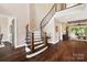 Elegant foyer with a curved staircase, dark wood floors, and an open view into the living room at 13106 Bien Ct, Huntersville, NC 28078